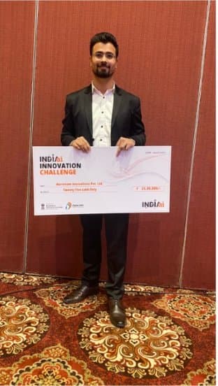Representative holding the IndiaAI Innovation Challenge award cheque made out to Narottam Innovations Pvt Ltd.